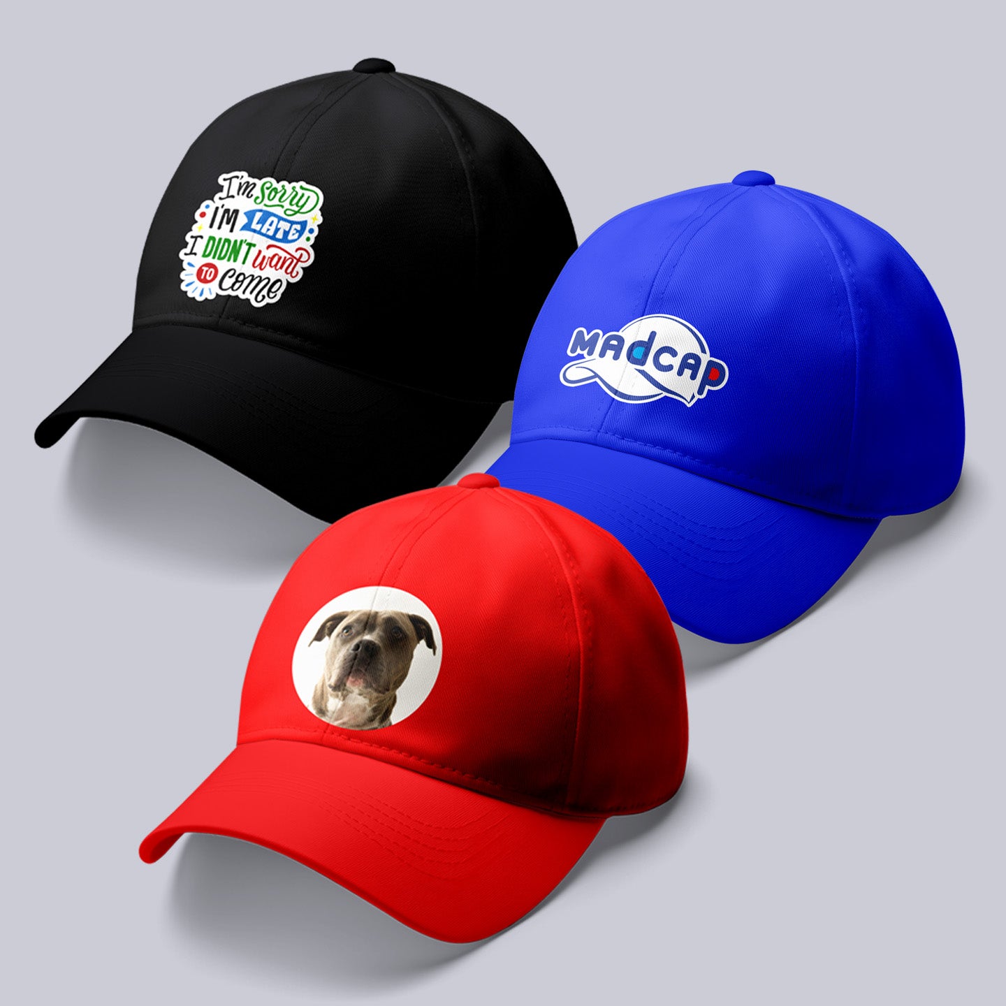 Three baseball caps in black, red, and blue with different designs on a gray background